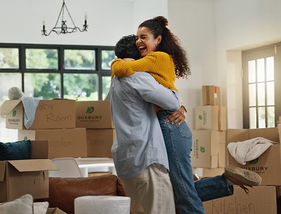 Young couple hugging moving into a new home