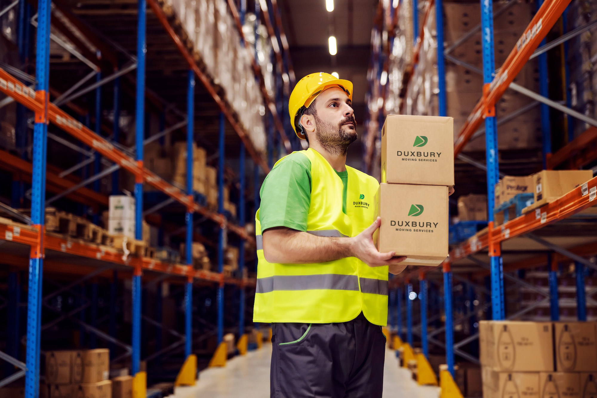 Duxbury Moving employee working on commercial move in warehouse with boxes