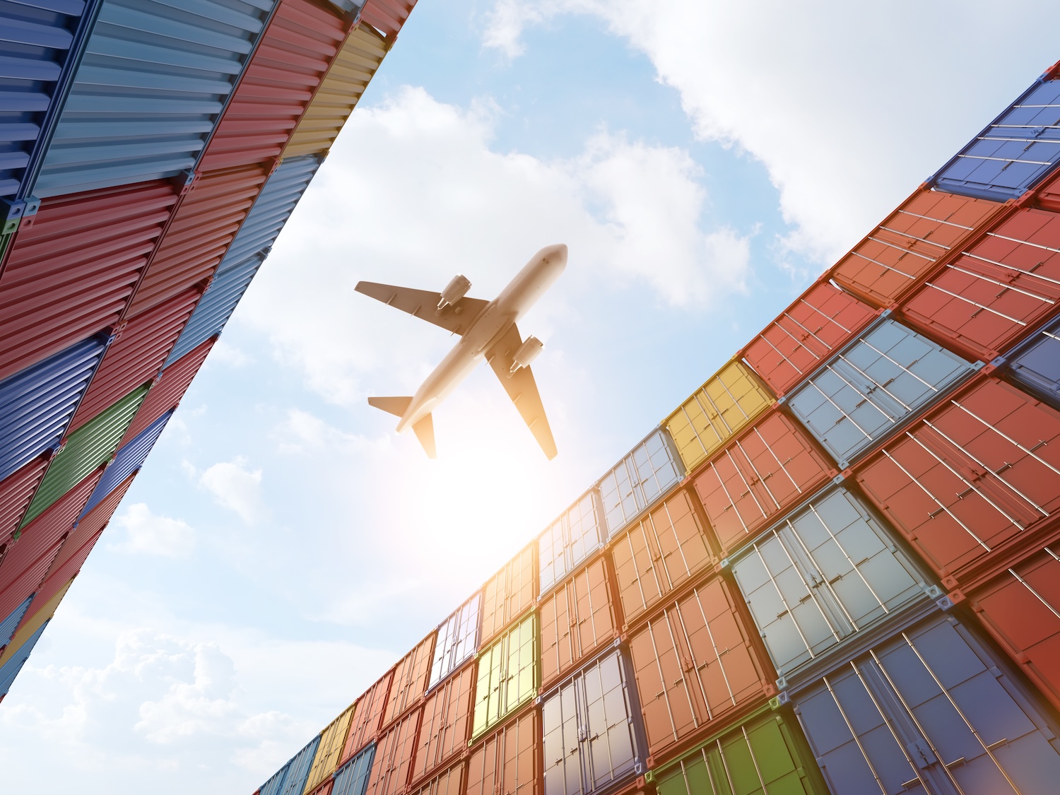 Airplane flying over shipping containers